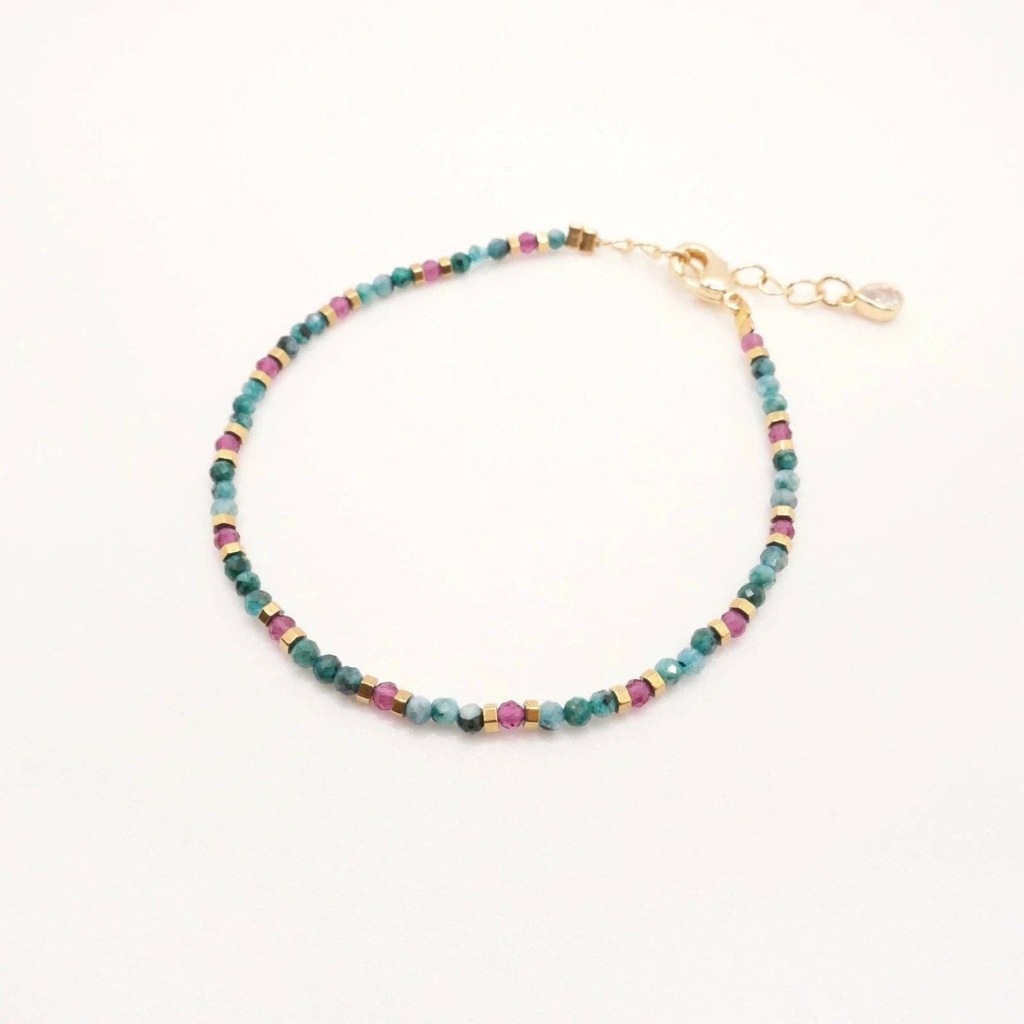 Bracelet Alicia présenté à plat, mettant en valeur ses nuances bordeaux et turquoise.