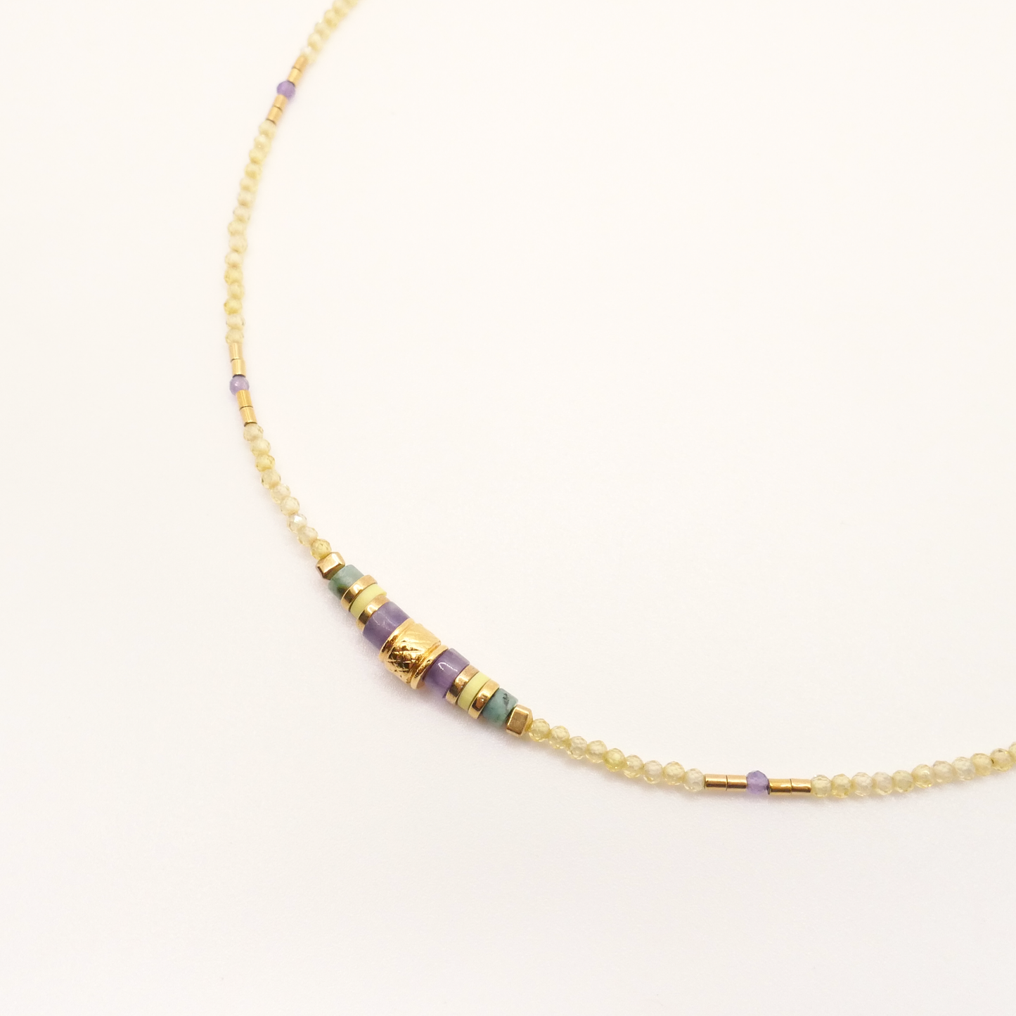 Gros plan sur le Collier Nona mettant en valeur ses perles colorées et sa perle centrale dorée