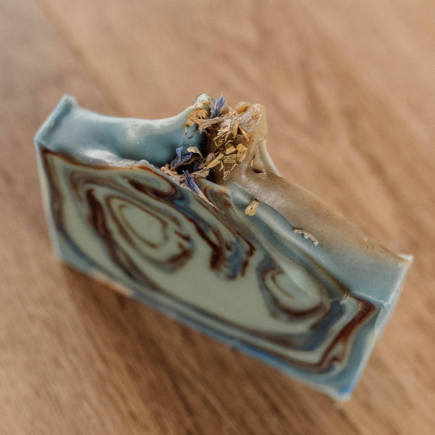 Gros plan du savon sans emballage, mettant en valeur ses marbrures vertes et naturelles.