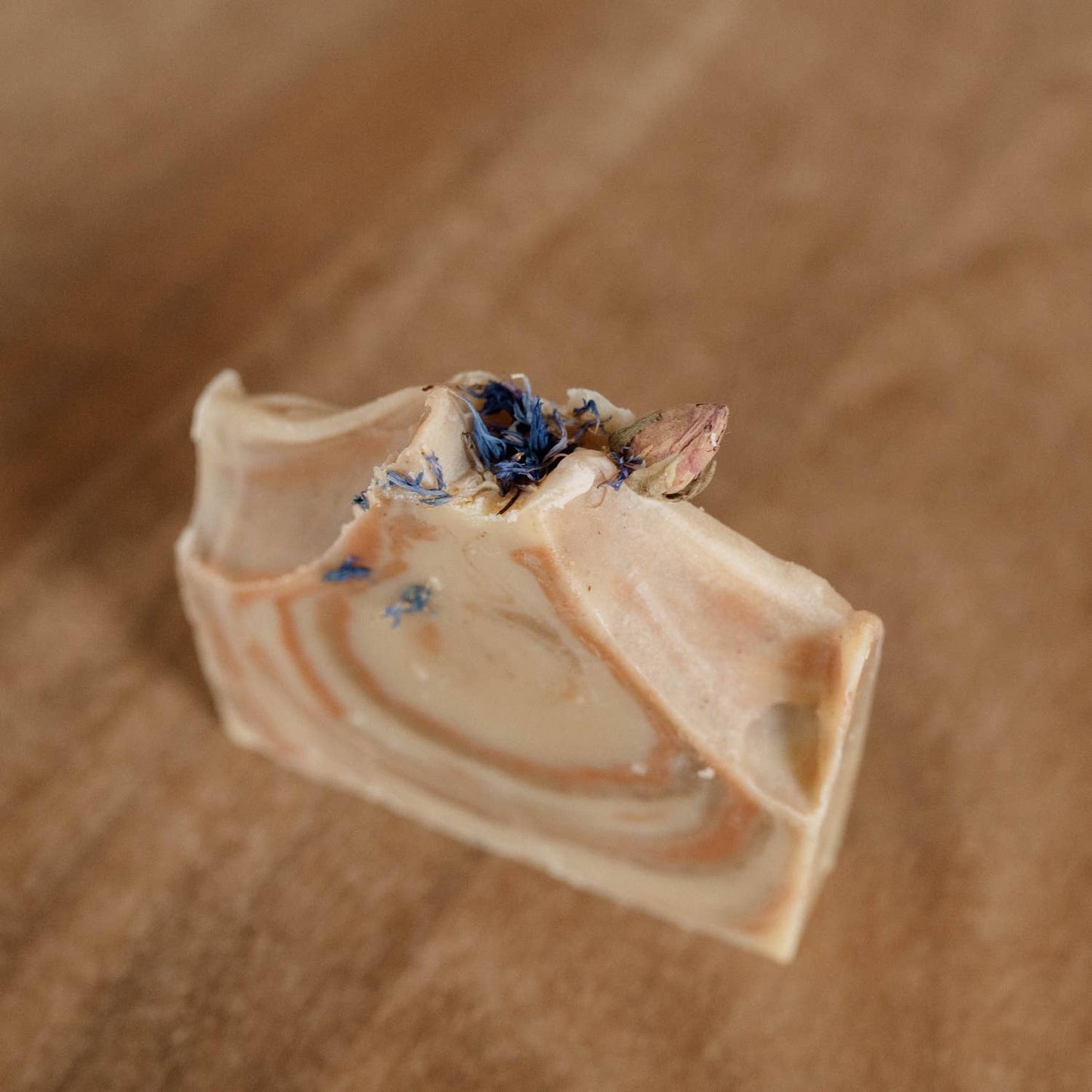 Gros plan sur le savon, révélant ses nuances et décorations naturelles.