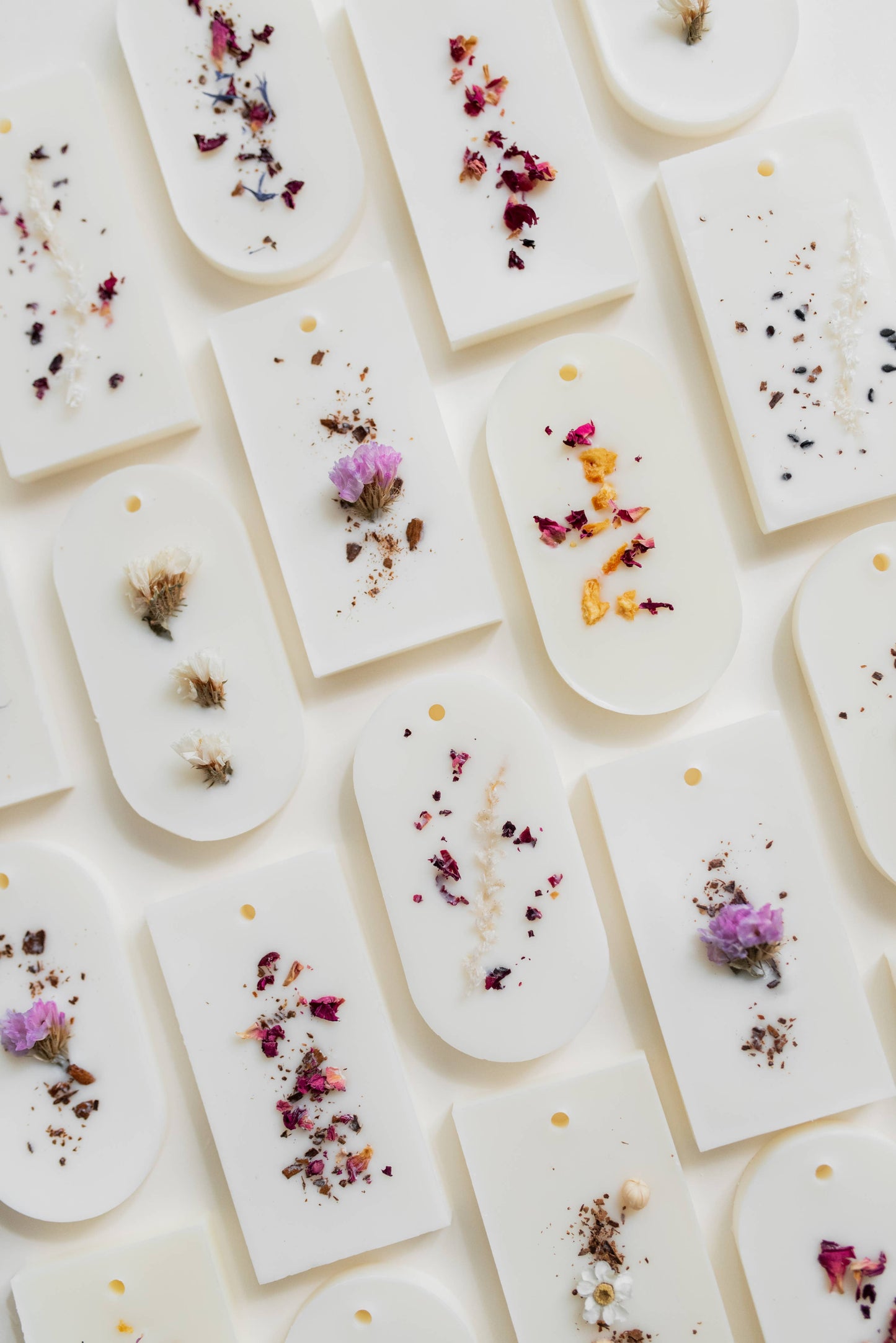 Composition de plusieurs tablettes parfumées disposées en mosaïque, toutes ornées de fleurs séchées variées — met en avant l’aspect artisanal et la singularité de chaque création.