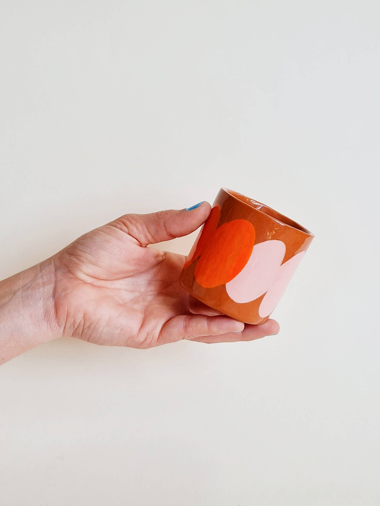 Tasse en main, soulignant son format pratique et convivial.