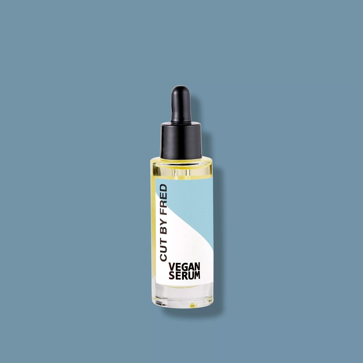 Flacon de Vegan Serum Cut By Fred, sérum capillaire anti-frisottis naturel, packshot sur fond bleu.