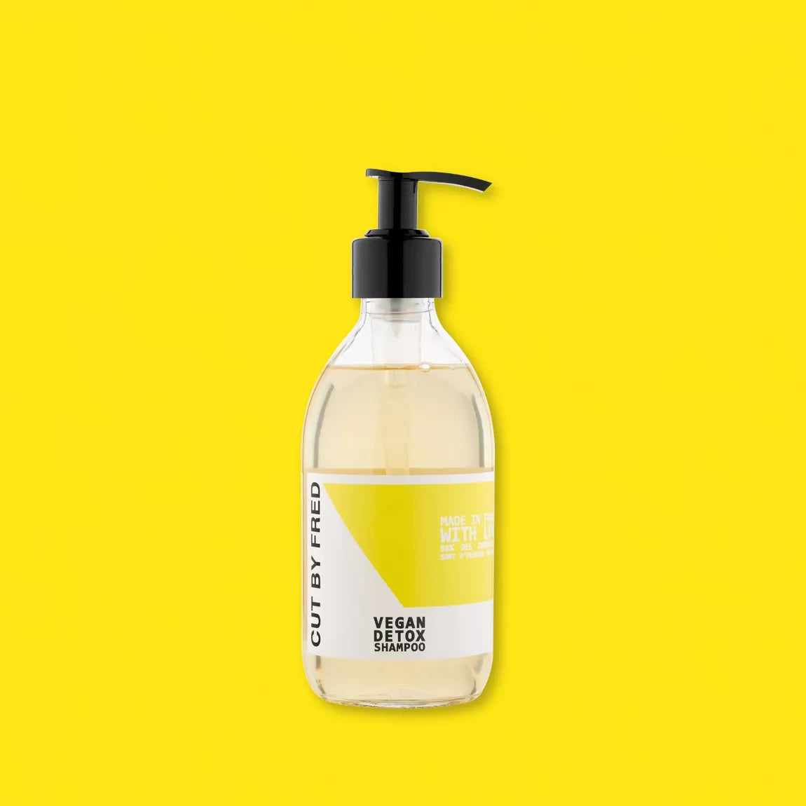 Flacon du Vegan Detox Shampoo Cut By Fred, shampoing purifiant naturel, packshot sur fond jaune.