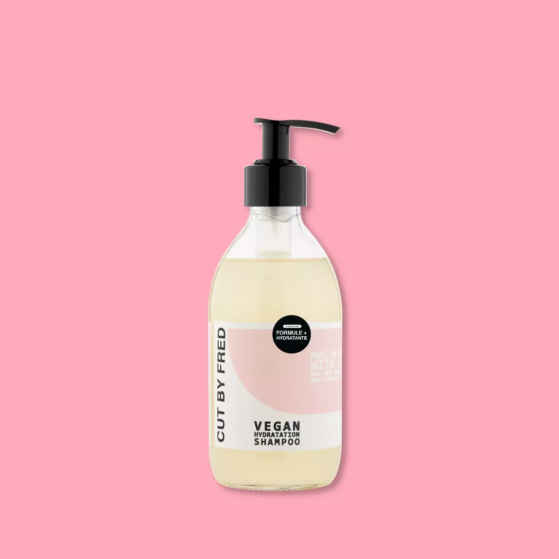 Flacon du Vegan Hydration Shampoo Cut By Fred, shampoing doux hydratant naturel, packshot sur fond rose.