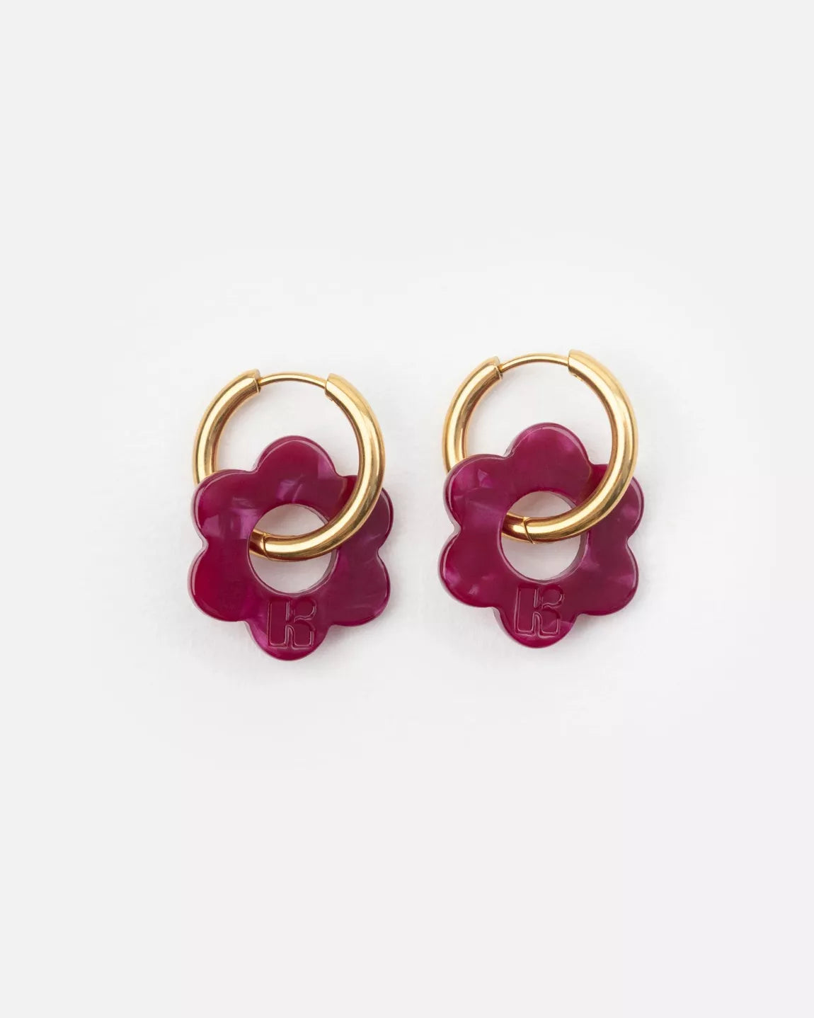 Détail des boucles d’oreilles BABY FLEURETTE Kurage Ginza, fleurs bordeaux en acétate de cellulose gravées du logo K, avec anneaux dorés en acier inoxydable.