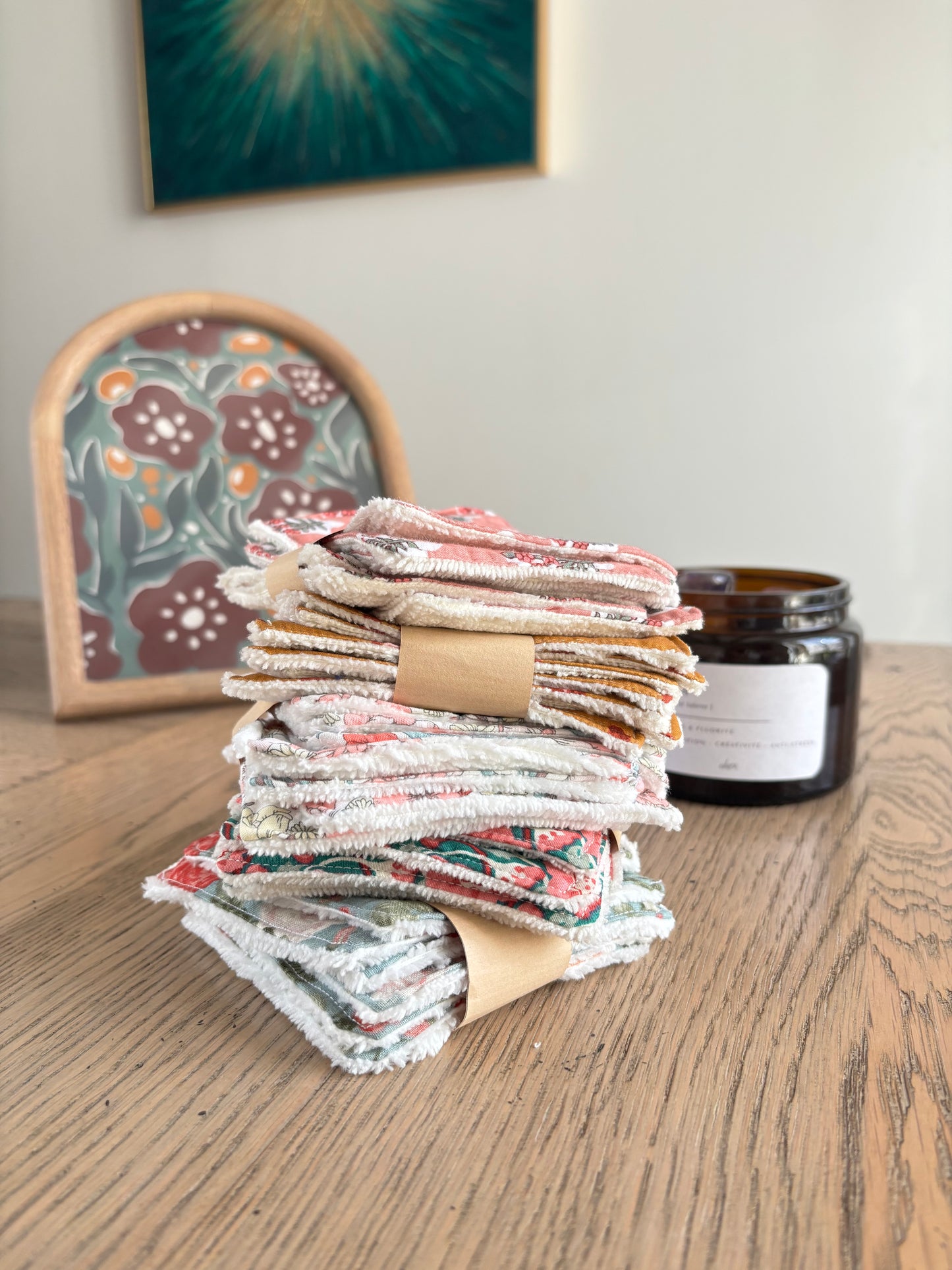 Semainiers de lingettes lavables Marie en Août empilés sur une table en bois clair, fabriqués en France avec éponge douce et tissus fleuris – artisanat écoresponsable.
