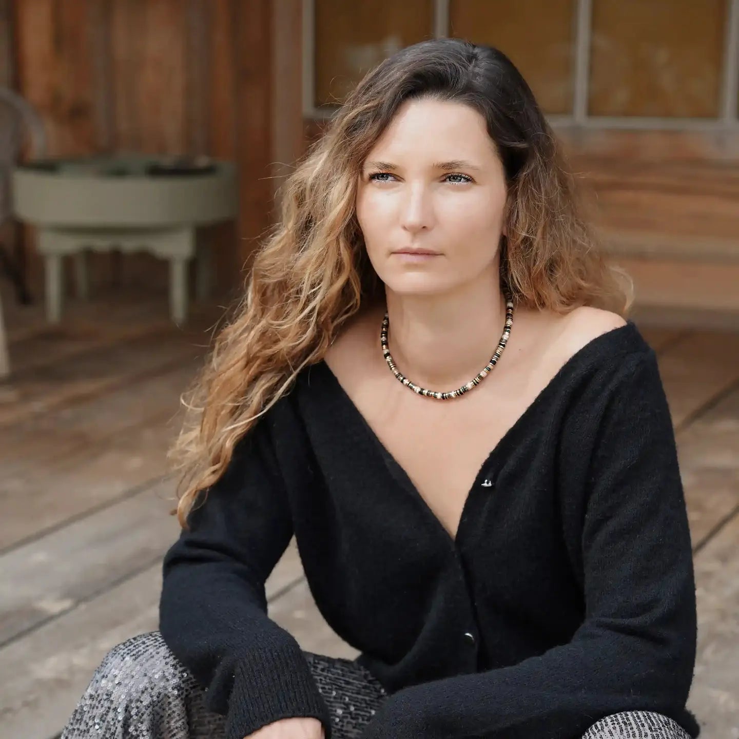 Modèle portant le collier Elwood Noir Cloralys, collier court en perles heishi noires, dorées et ivoire. 