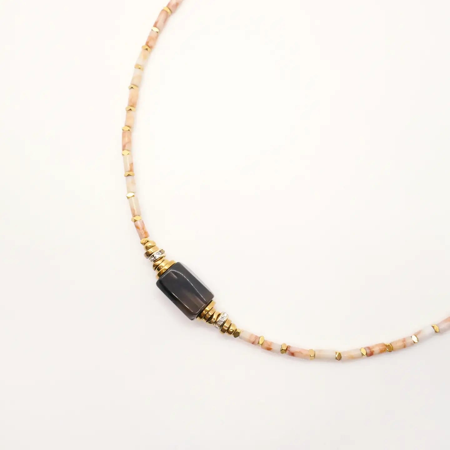 Gros plan sur le collier Ysé porté en ras-de-cou, perles jaspe beiges et pierre centrale noire – bijou artisanal Cloralys.