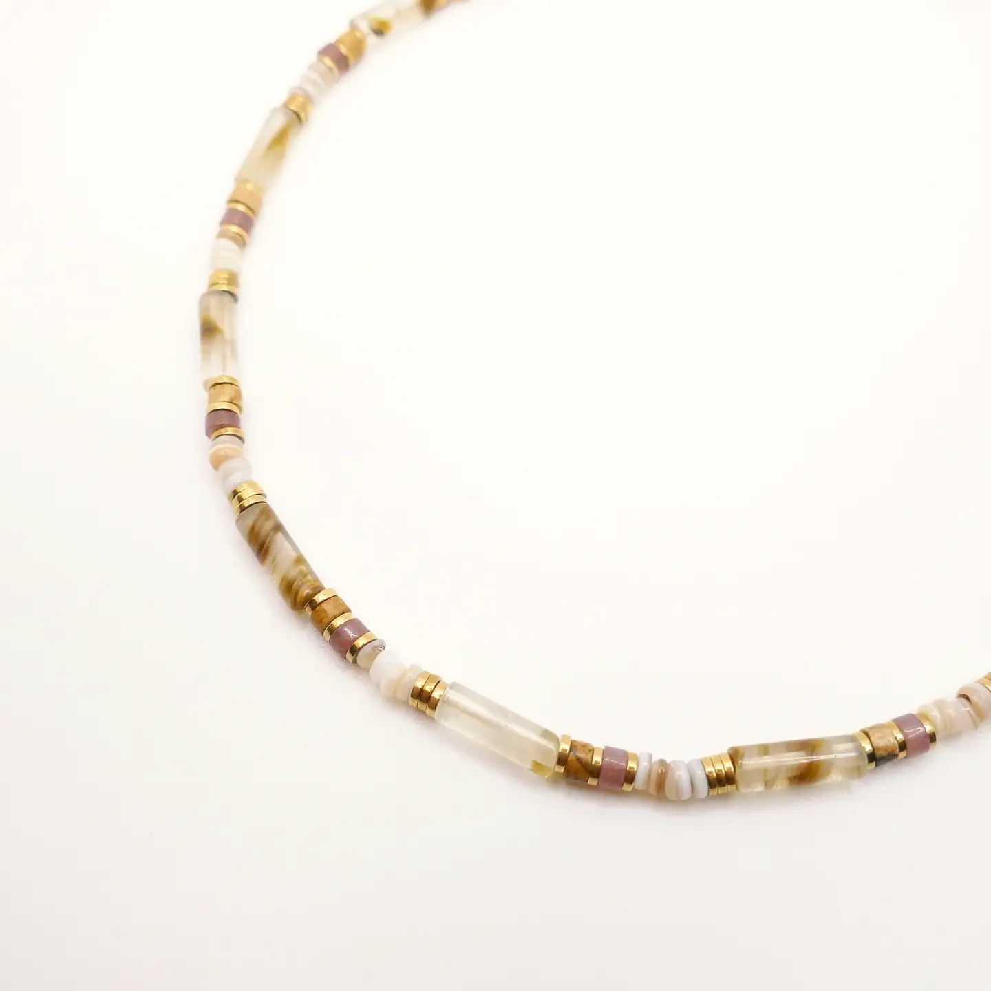 ros plan sur le collier Alma, composé de perles fines beige, mauve et dorées, montées sur une chaîne délicate.