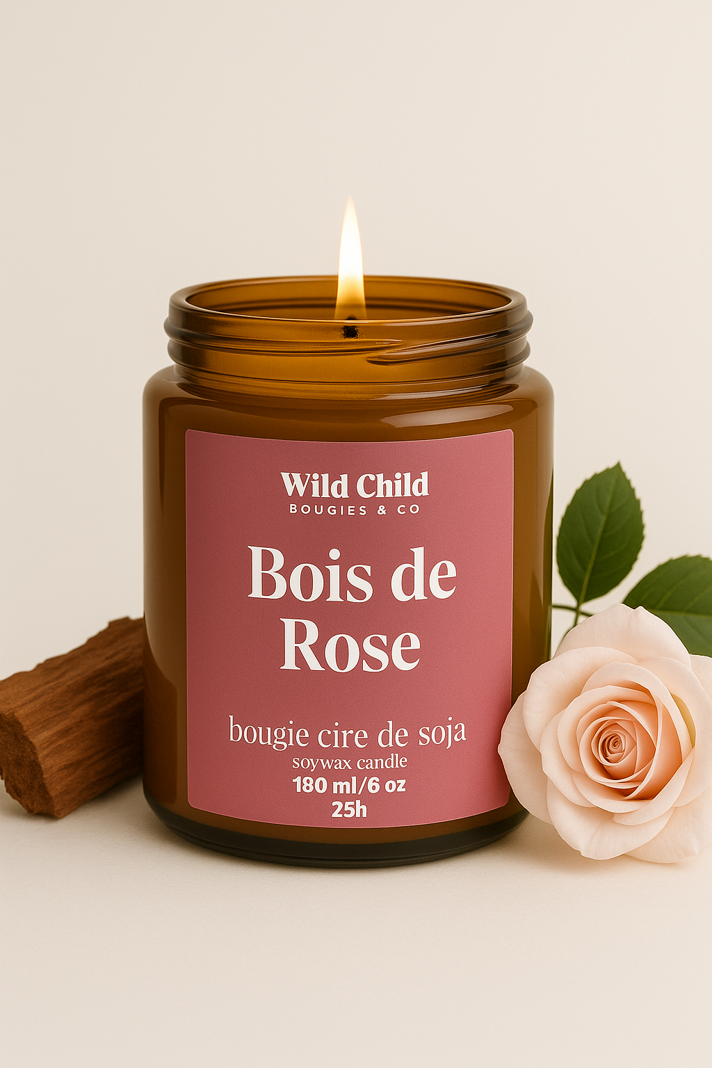 Bougie Bois de Rose allumée, pot ambré, accompagnée d’une rose pâle et d’un bâton de cannelle, ambiance douce et florale.